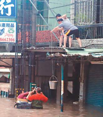 ●屏東縣佳冬鄉發生五十年最大水患，部分住戶因停電導致電動門打不開，受困民眾只好以吊繩方式領取救援食物。記者宋耀光／攝影【20090810聯合報】